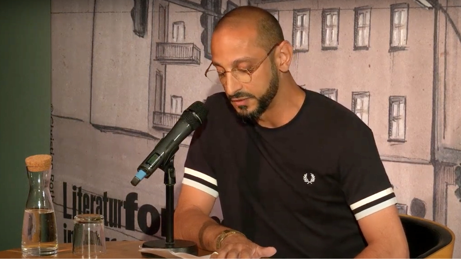Behzad Karim Khani sitzt im Literaturforum im Brechthaus und liest aus seinem Text.